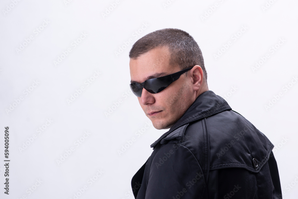 Close-up portrait of serious man in sunglasses and trench coat standing isolated on white background Close-up portrait of serious man in sunglasses and trench coat standing isolated on white background