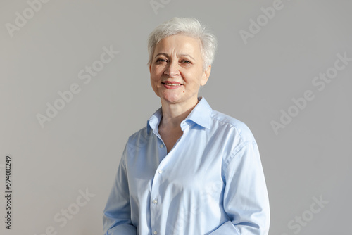 Confident stylish european middle aged senior woman. Older mature 60s lady smiling in white background. Happy attractive senior female looking camera close up face headshot portrait. Happy people