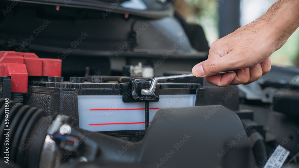 A man is maintenance on his car, checking and change the battery. Car maintenance concept. A man is maintenance on his car, checking and change the battery. Car maintenance concept.
