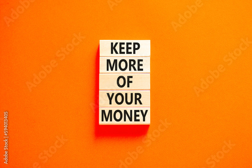 Keep more of your money symbol. Concept words Keep more of your money on wooden block. Beautiful orange table orange background. Business keep more of your money concept. Copy space.