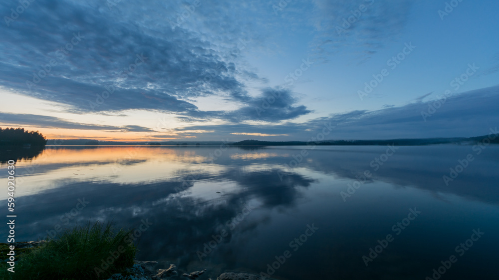 Summer lake scenery with clouds reflected on the water in Finland Summer lake scenery with clouds reflected on the water in Finland