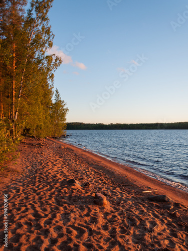 Setting sun colouring the beach sand red in summer in Finland