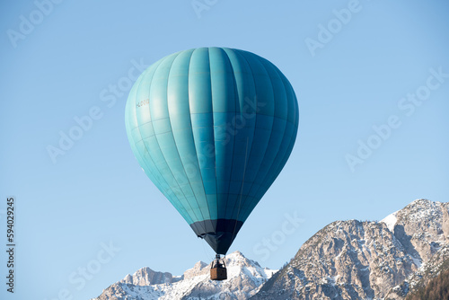 una bella mongolfiera di colore blu in volo sulle dolomiti