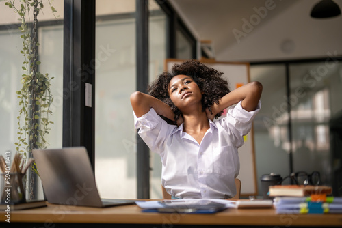 Black woman getting physically active from fatigue sitting at a desk. tired from work, Twisting due to pain, Office syndrome of office workers
