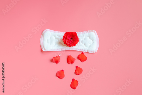 Sanitary pad and red flower on pink background. Menstruation concept. #594040635