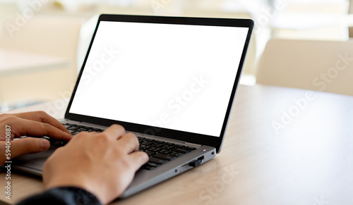 close up on white blank mockup display (isolated) with employee young man hand typing on laptop to check or work on table for business technology concept
