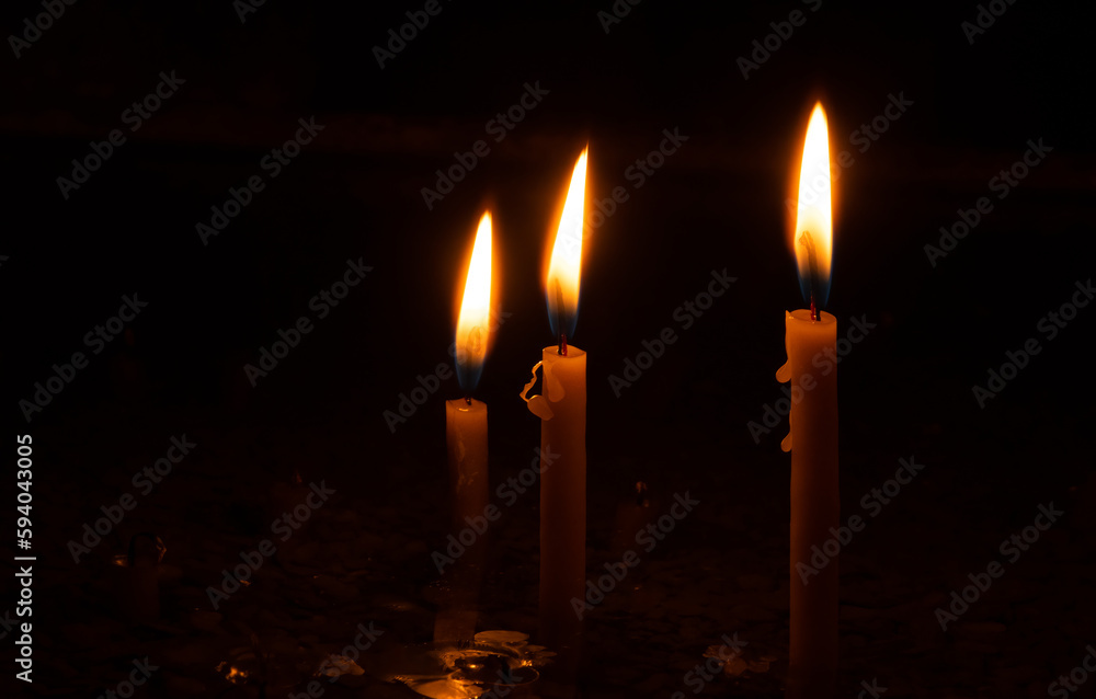 Three burning wax candles. Three candles concept.