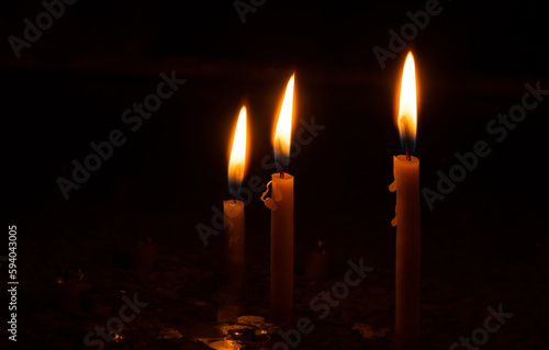 Three burning wax candles. Three candles concept.