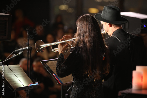 Trumpeter playing a musical instrument in a group of musicians