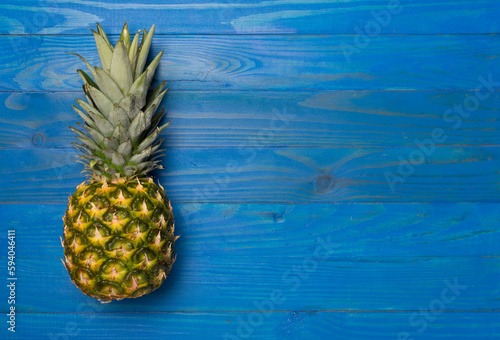 Fresh pineapple on wooden background, top view