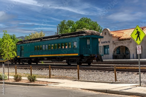 Green train cabin parked in front of the train station in Santa Fe and a road sign