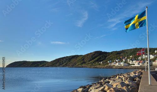 Swedish and Norwegian flags hoisted on mats on the coast of a village
