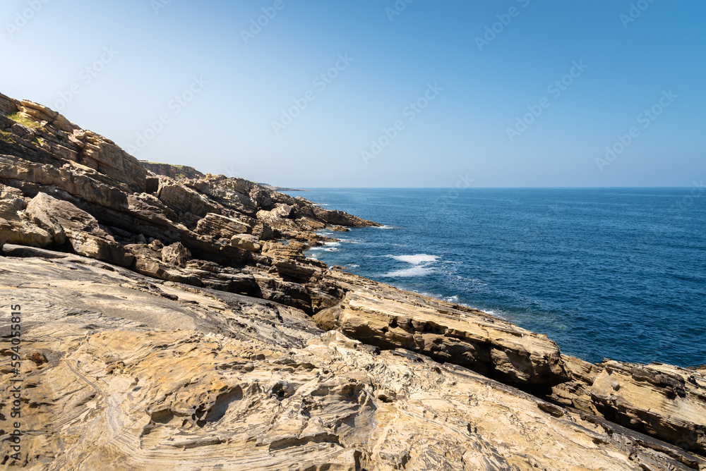 Top view of the Cantabrian Sea coast with a small quiet rocky cove and a green mountain on a sunny day, Hondarribia, Gipuzkoa, Basque Country, Spain