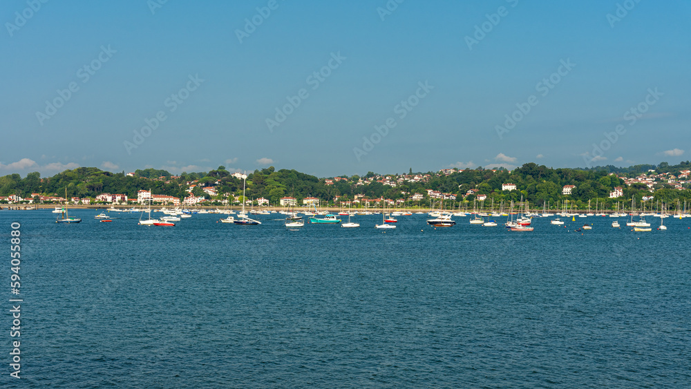 Bidasoa river crowded of boat with the french village of Hendaye in the background in a day with blue sky, Hondarribia, Guipuzcoa, Basque Country, Spain