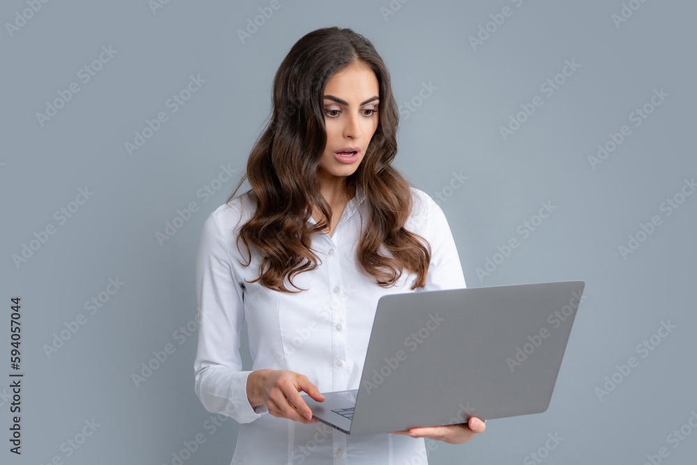 Portrait of young businesswoman using laptop computer isolated on gray background. Business women in shirt excited something in laptop screen. Portrait of business lady holding notebook. Portrait of young businesswoman using laptop computer isolated on gray background. Business women in shirt excited something in laptop screen. Portrait of business lady holding notebook.