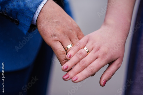 Wedding gold rings on the hands of the newlyweds. Gold rings on the hand of a man and a woman