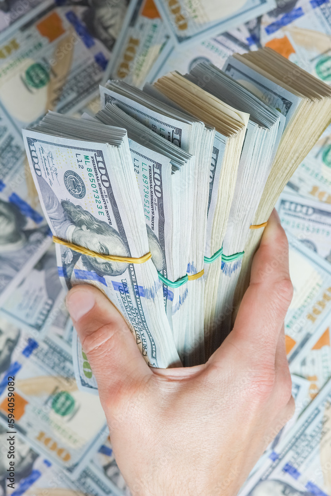 Φωτογραφία A hands with dollars on the background of money concept of business banknotes in