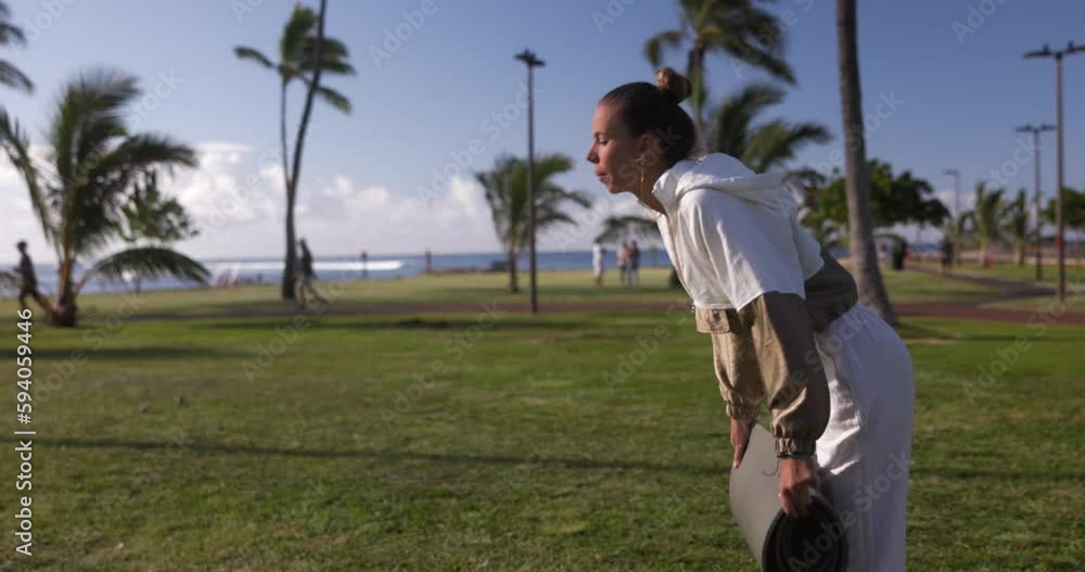 Young woman doing yoga and meditation outside on the grass with palm trees in Hawaii Young woman doing yoga and meditation outside on the grass with palm trees in Hawaii