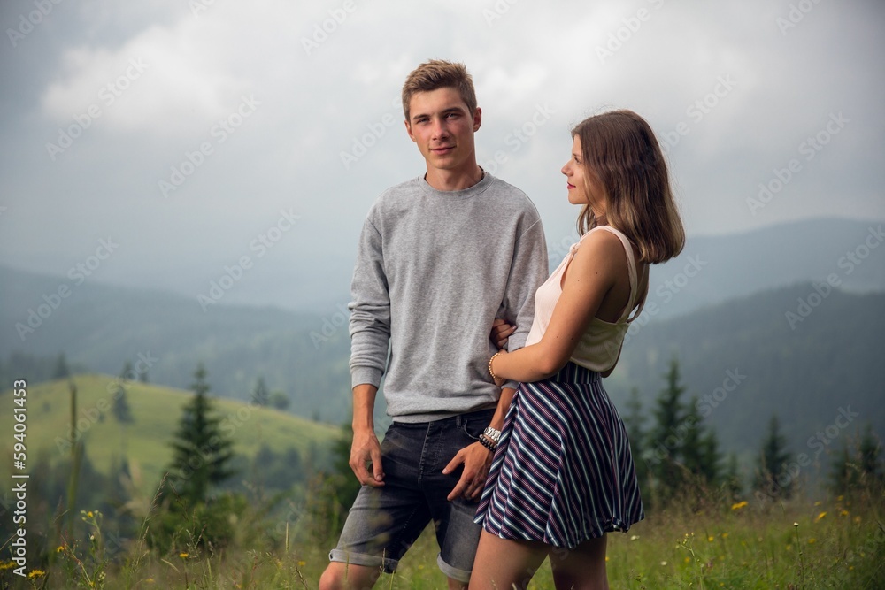 Caucasian white couple posing on the background of green hills