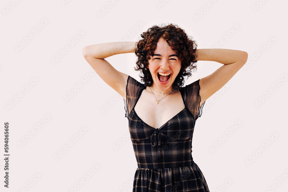 young woman laughing hands on hair, toothy smile, wearing dress in studio shot young woman laughing hands on hair, toothy smile, wearing dress in studio shot