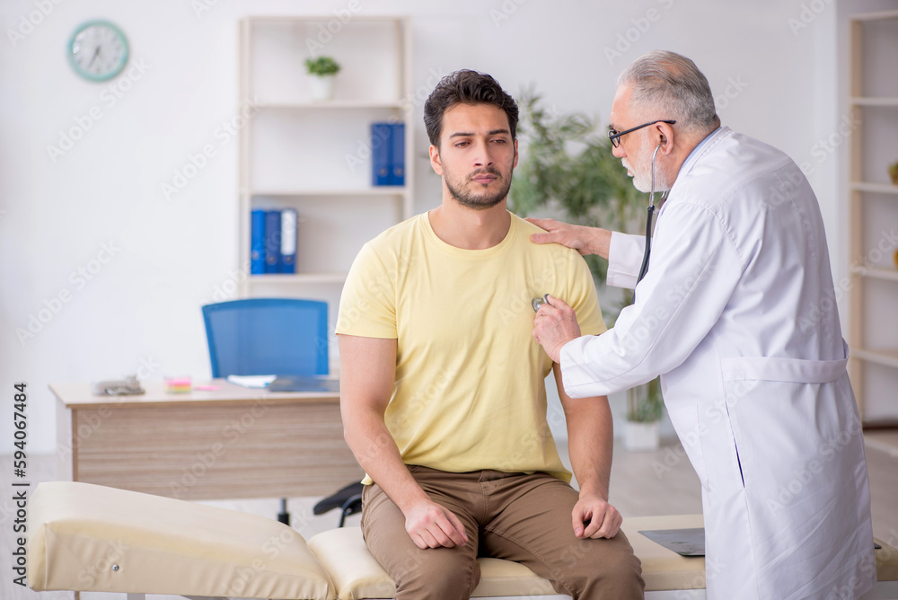 Young male patient visiting old male doctor Young male patient visiting old male doctor