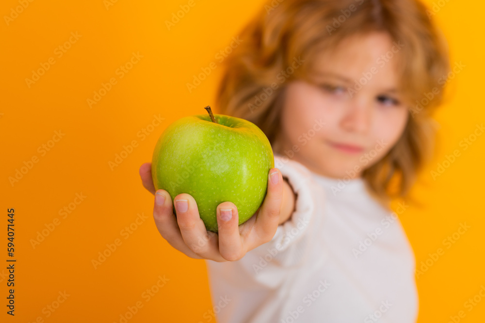 Healthy fruits for kids. Kid with apple in studio. Studio portrait of cute child hold apple isolated on yellow background. Healthy fruits for kids. Kid with apple in studio. Studio portrait of cute child hold apple isolated on yellow background.