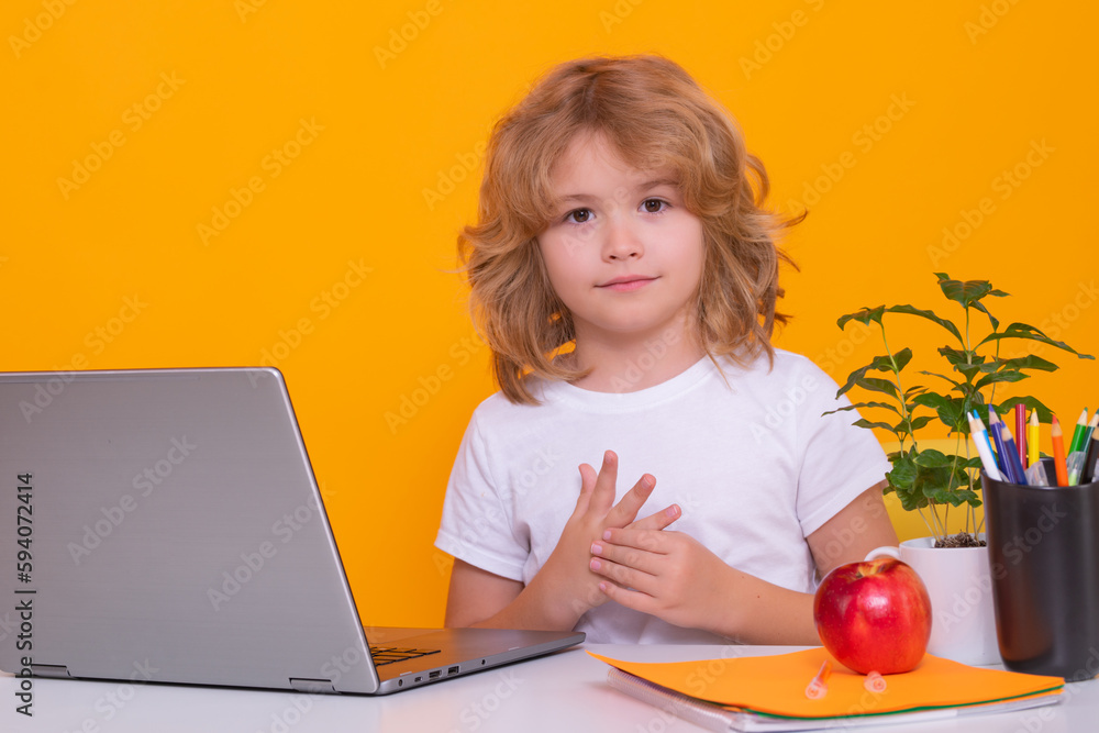 School child using laptop computer. Smart caucasian school boy kid pupil student going back to school. Education kids. School boy isolated on yellow studio background. School child using laptop computer. Smart caucasian school boy kid pupil student going back to school. Education kids. School boy isolated on yellow studio background.