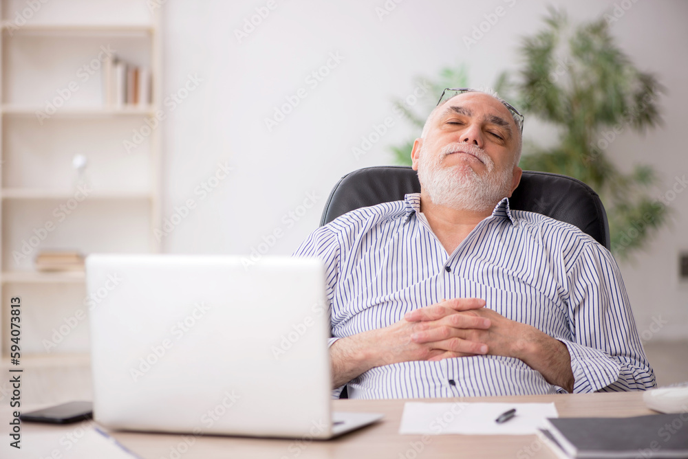 Old male employee working in the office Old male employee working in the office