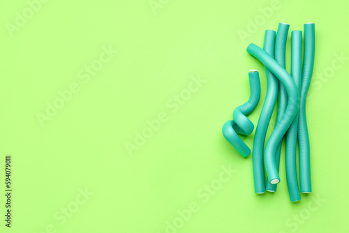 Hair curlers on green background