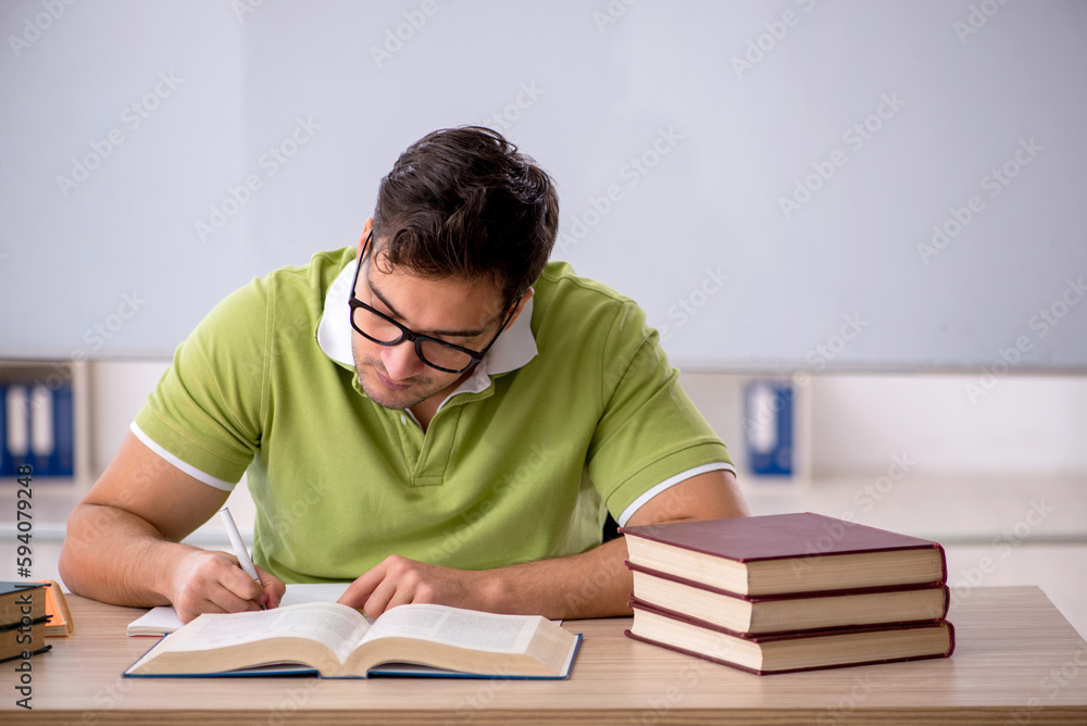 Young male student preparing for exams in the classroom Young male student preparing for exams in the classroom