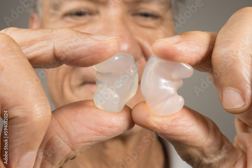 Older Man showing off his custom made silicone earplugs for hearing protection