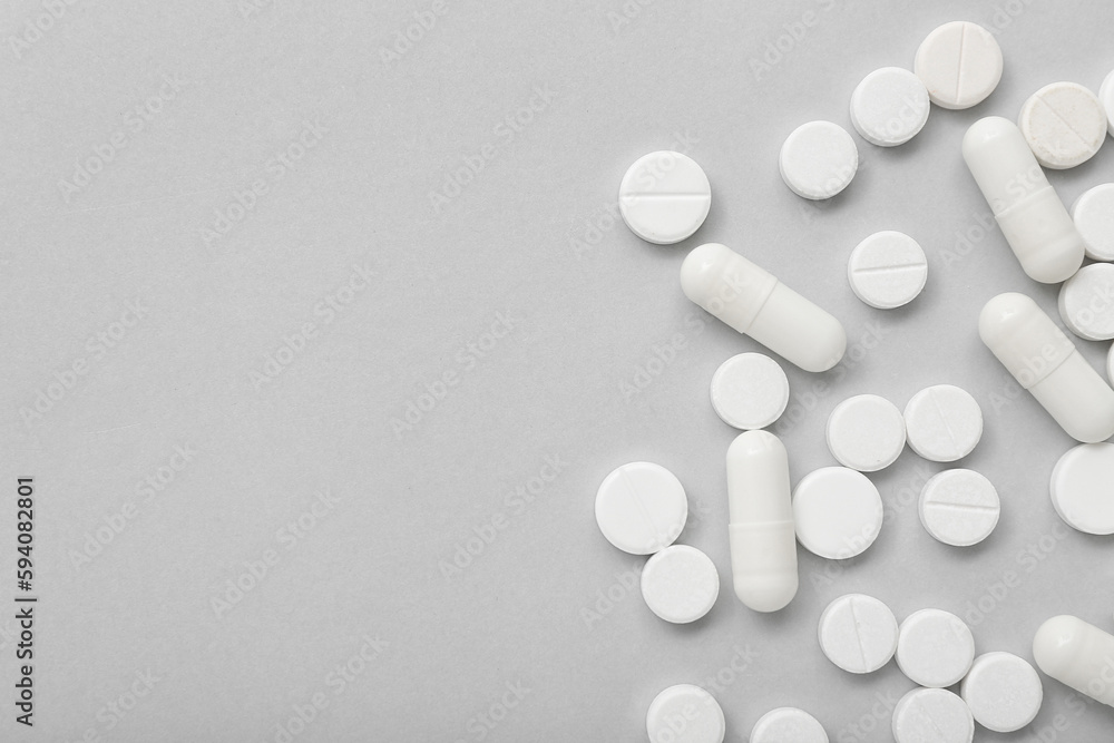 White pills on grey background White pills on grey background