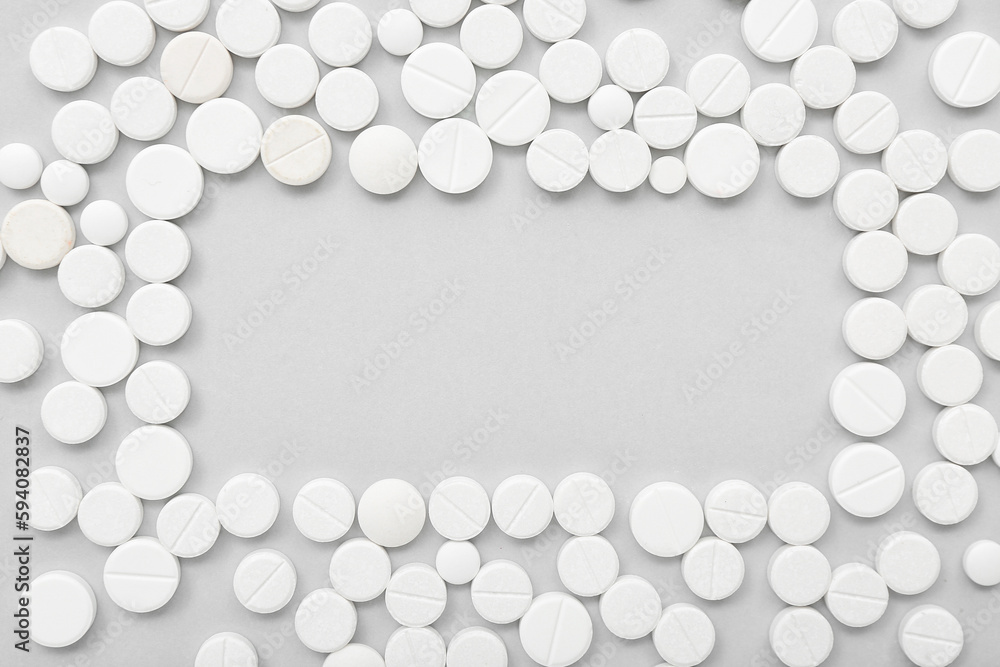 Frame made of white pills on grey background Frame made of white pills on grey background