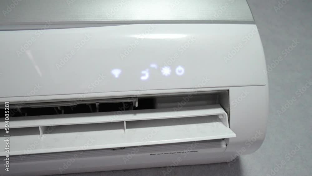 White air conditioner on white wall against background of interior of room is turned on, shows high temperature of 32 degrees, concept of heating room. Heating with warm air. White air conditioner on white wall against background of interior of room is turned on, shows high temperature of 32 degrees, concept of heating room. Heating with warm air.
