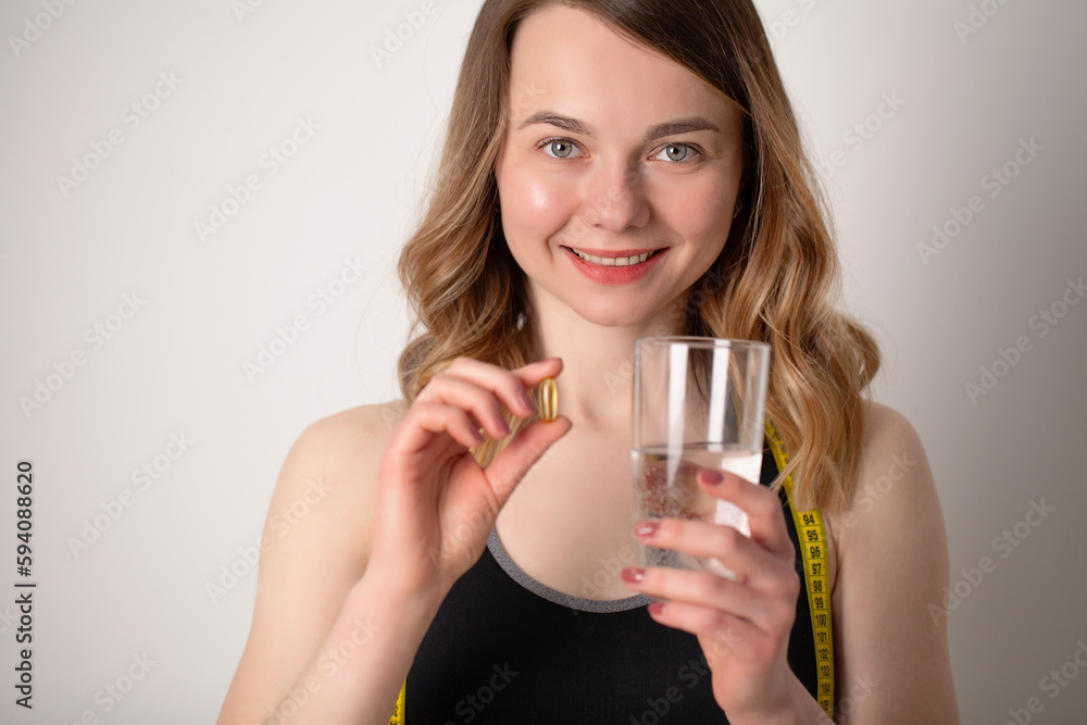 Portrait of smiling young woman with Omega 3 fish oil capsule Portrait of smiling young woman with Omega 3 fish oil capsule