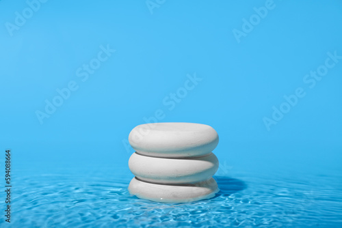 Stack of stones in water on blue background