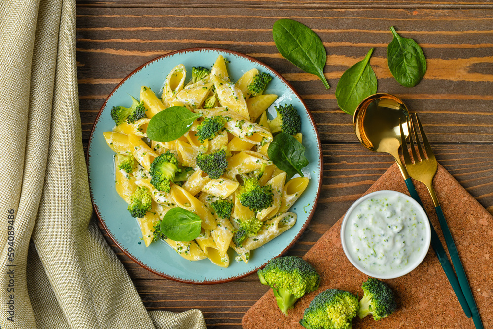 Plate with tasty pasta and broccoli on wooden background Plate with tasty pasta and broccoli on wooden background