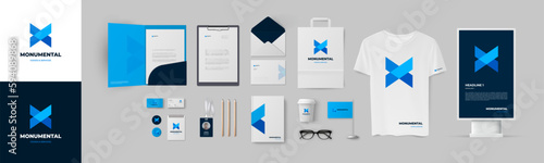 Blue corporate branding template. Presentation of corporate identity design with folder, envelope, business cards and A4 form. Geometric minimal blue logo and color dark blue background. Vector set.