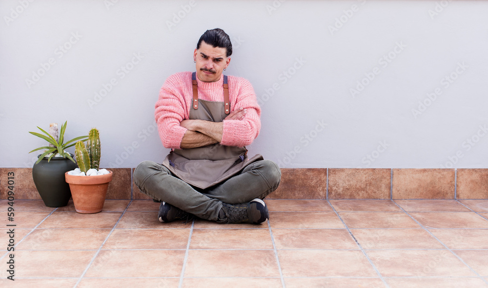 young handsome man gardering and sitting on the floor outdoors young handsome man gardering and sitting on the floor outdoors