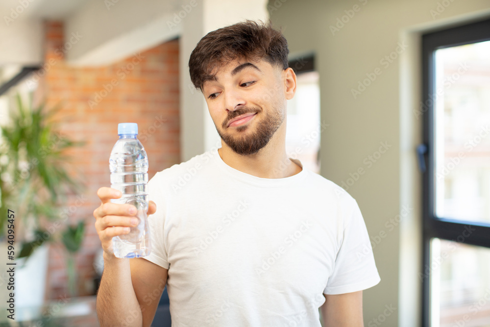 young handsome man smiling and looking with a happy confident expression. water bottle concept young handsome man smiling and looking with a happy confident expression. water bottle concept