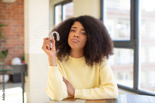 pretty afro black woman feeling sad and whiney with an unhappy look and crying. dental retainer concept