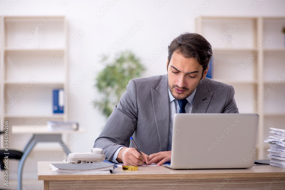 Young male employee and too much work in the office Young male employee and too much work in the office