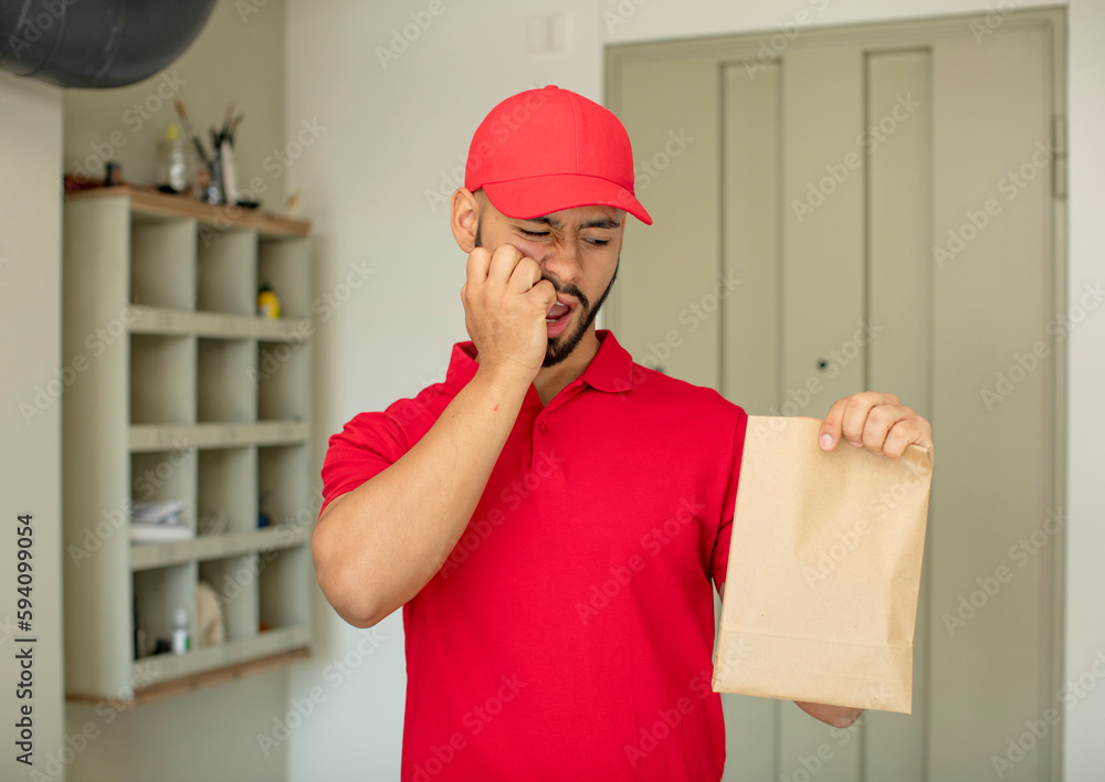 young adult man feeling scared, worried or angry and looking to the side. deliveryman concept young adult man feeling scared, worried or angry and looking to the side. deliveryman concept