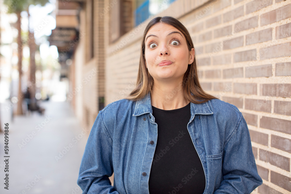 young pretty woman with a goofy, crazy, surprised expression, puffing cheeks, feeling stuffed, fat and full of food young pretty woman with a goofy, crazy, surprised expression, puffing cheeks, feeling stuffed, fat and full of food