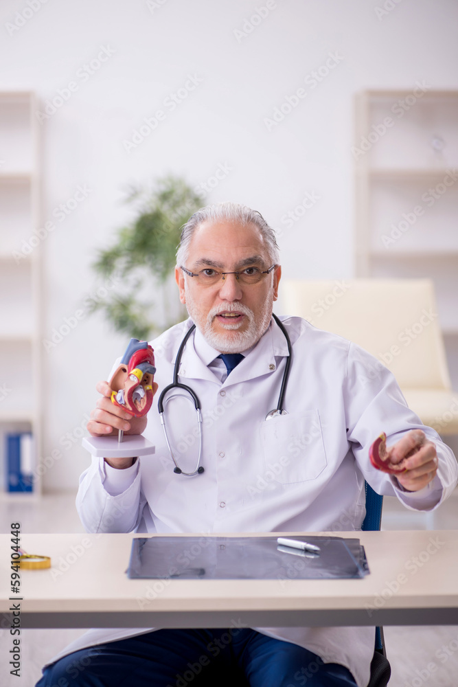 Old male doctor cardiologist working in the clinic Old male doctor cardiologist working in the clinic