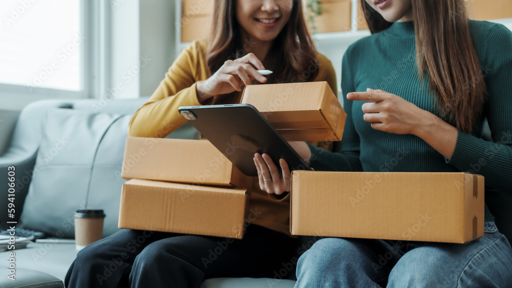 Checking clients address, Young pretty Asian female influencer small businesses SME owners female entrepreneurs working on receipt box and check online orders, sitting on sofa of home online business Checking clients address, Young pretty Asian female influencer small businesses SME owners female entrepreneurs working on receipt box and check online orders, sitting on sofa of home online business