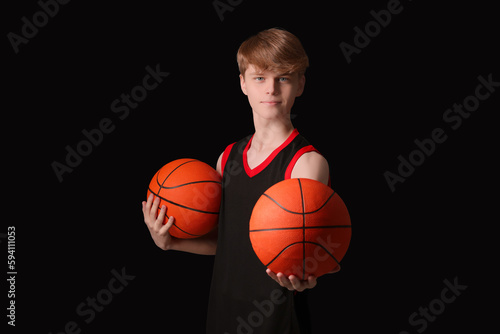 Teenage boy with basketball balls on black background