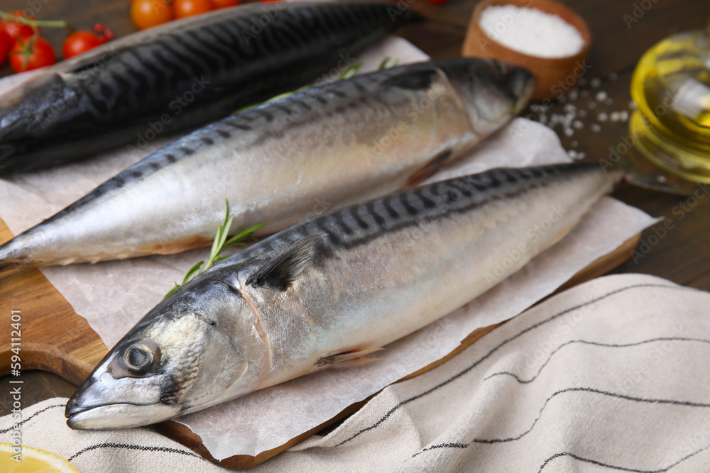 Raw organic mackerel fish on wooden board, closeup Raw organic mackerel fish on wooden board, closeup