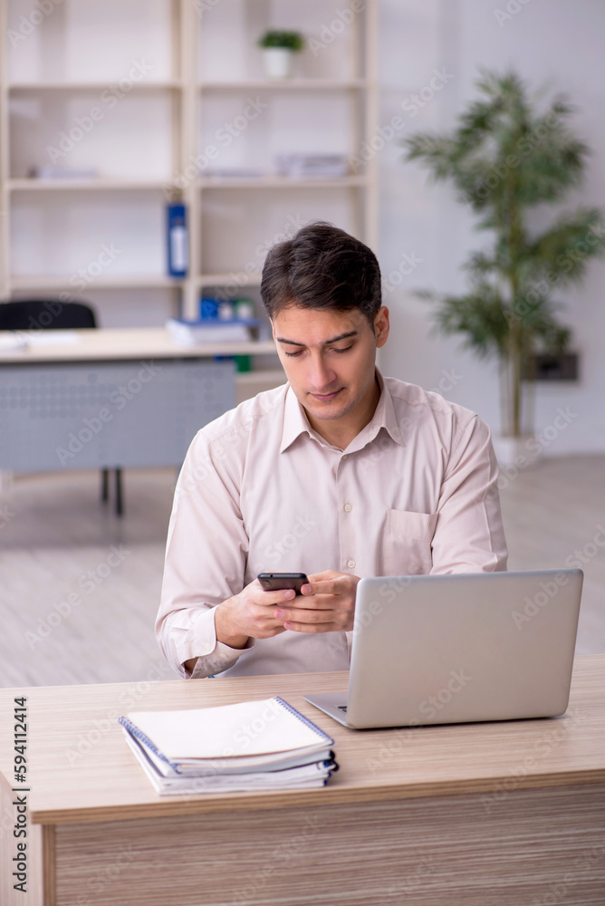 Young male employee working in the office Young male employee working in the office