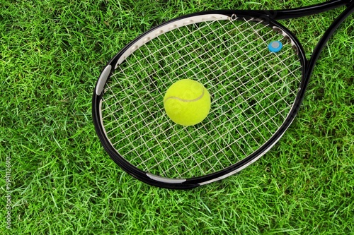 Sporty yellow balls and tennis racket on court